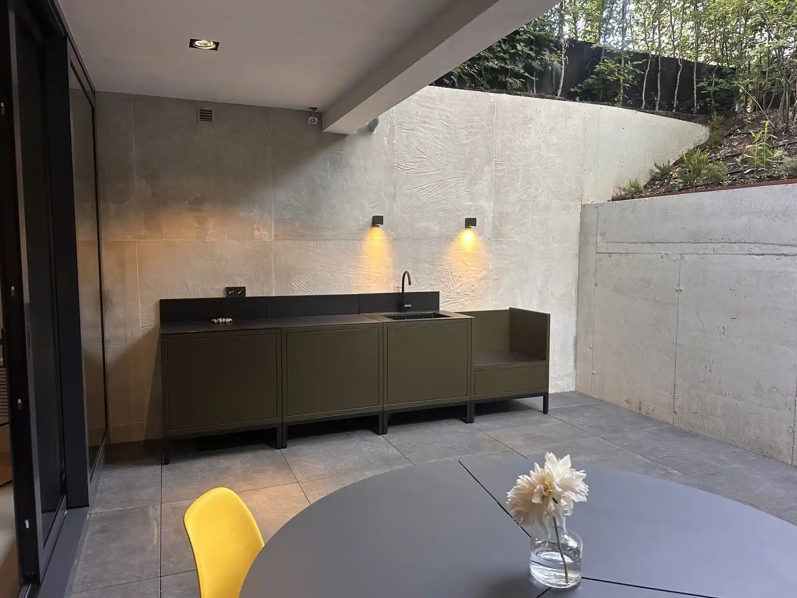 Cuisine extérieure Kokko coloris olive installée chez un client, terrasse avec vue sur jardin