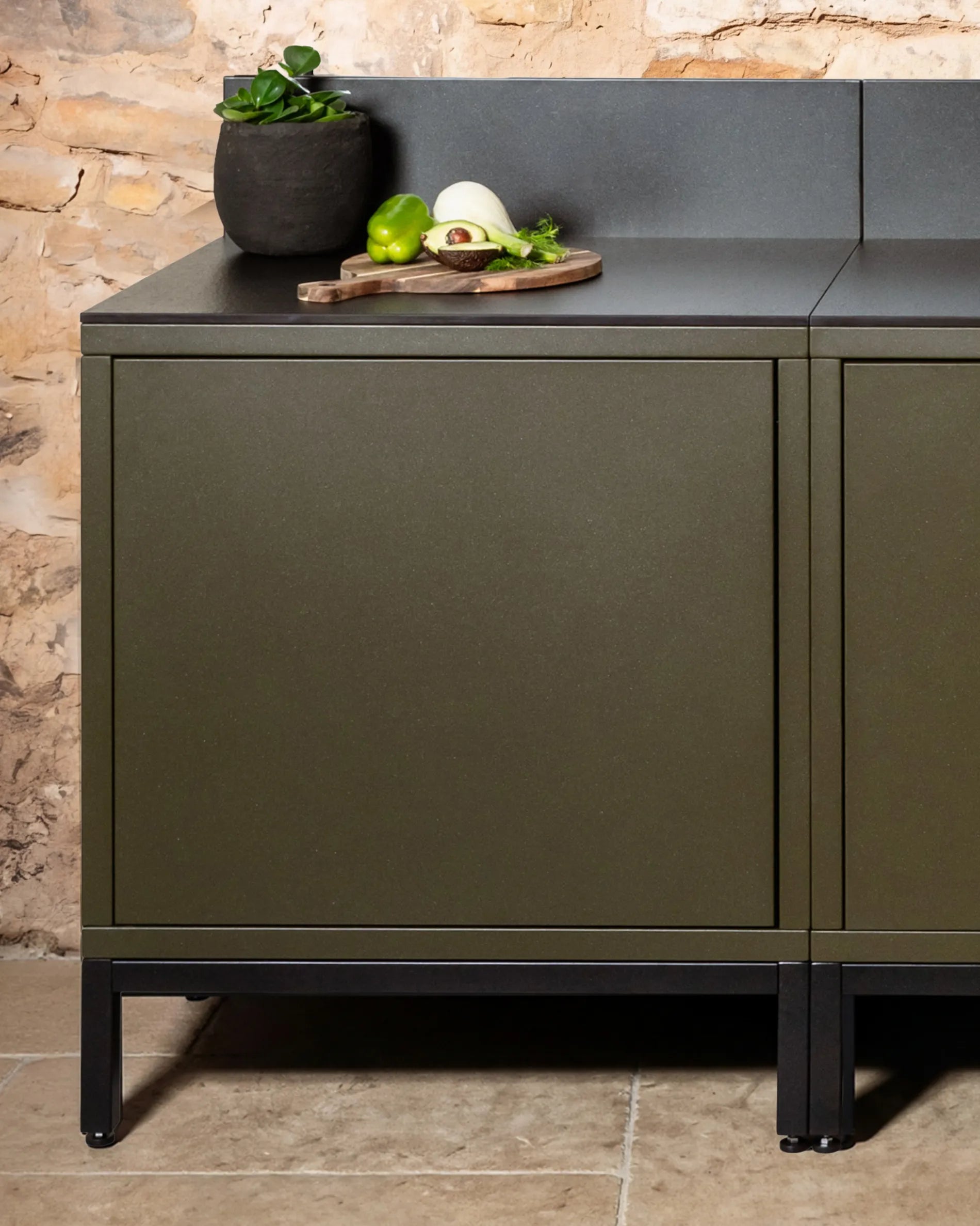 Structure basse noire PILOTIS sous caissons vert olive, cuisine extérieure avec plan de travail noir