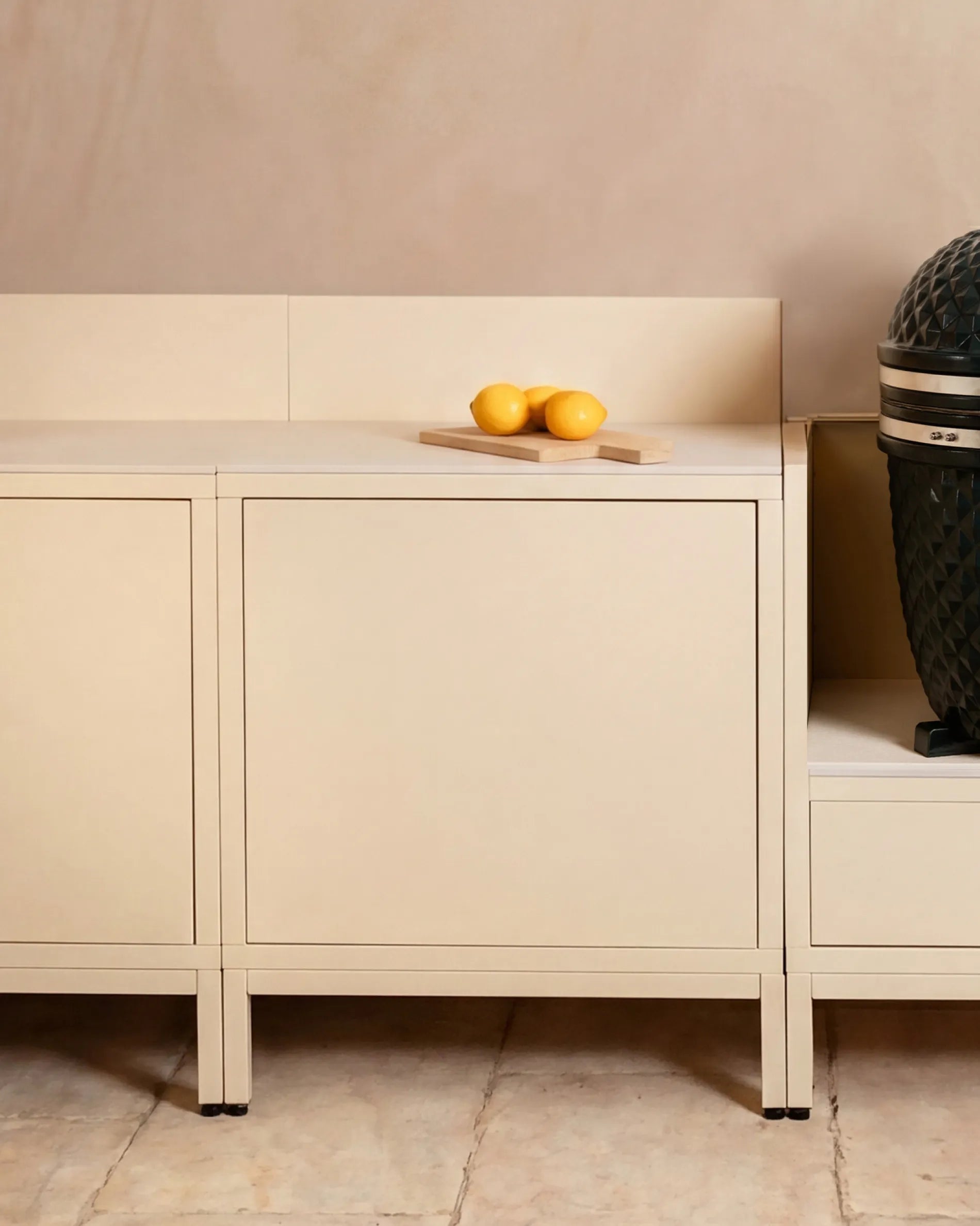 Caissons beige crème module Classic PILOTIS en cuisine extérieure, avec kamado et citrons sur planche