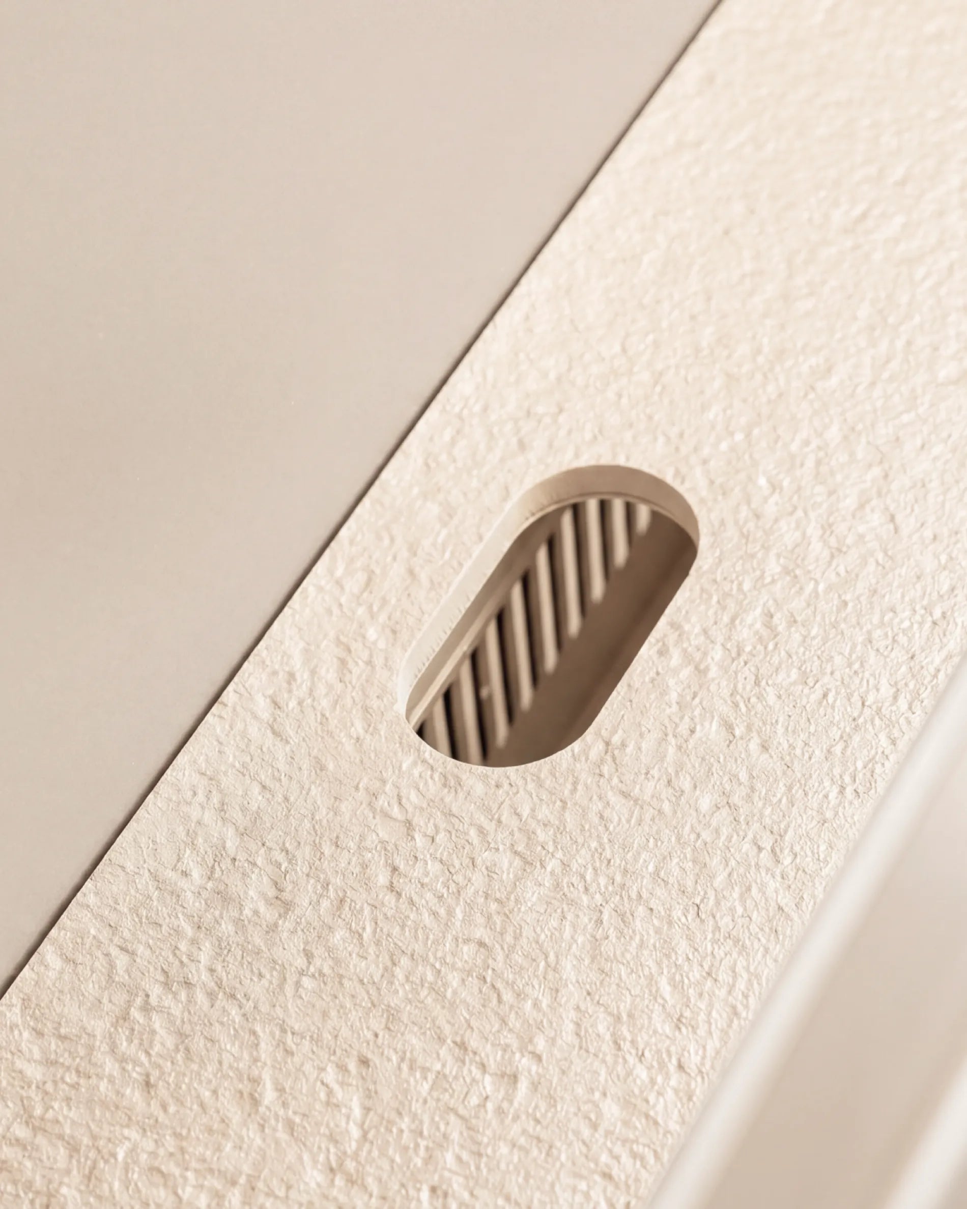 Découpe ovale du plateau beige crème module Plancha PILOTIS, gros plan texture granitée