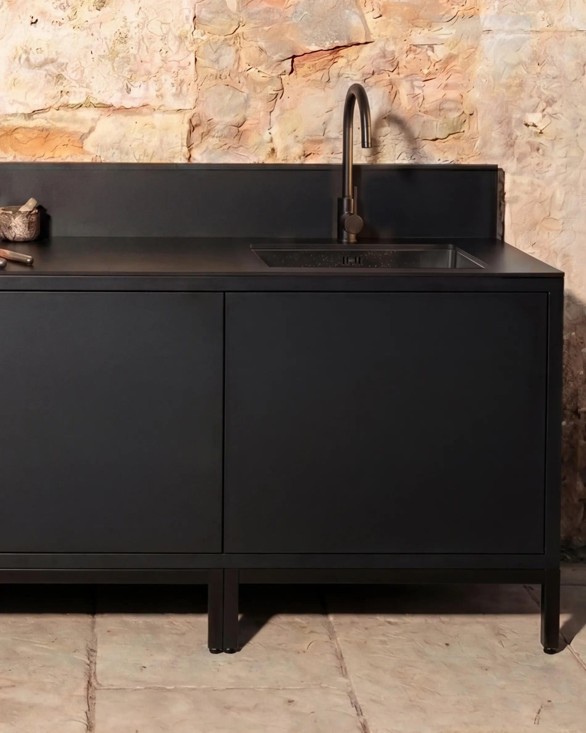 Caisson d'angle noir module Évier PILOTIS avec robinet, cuisine extérieure contre mur en pierre