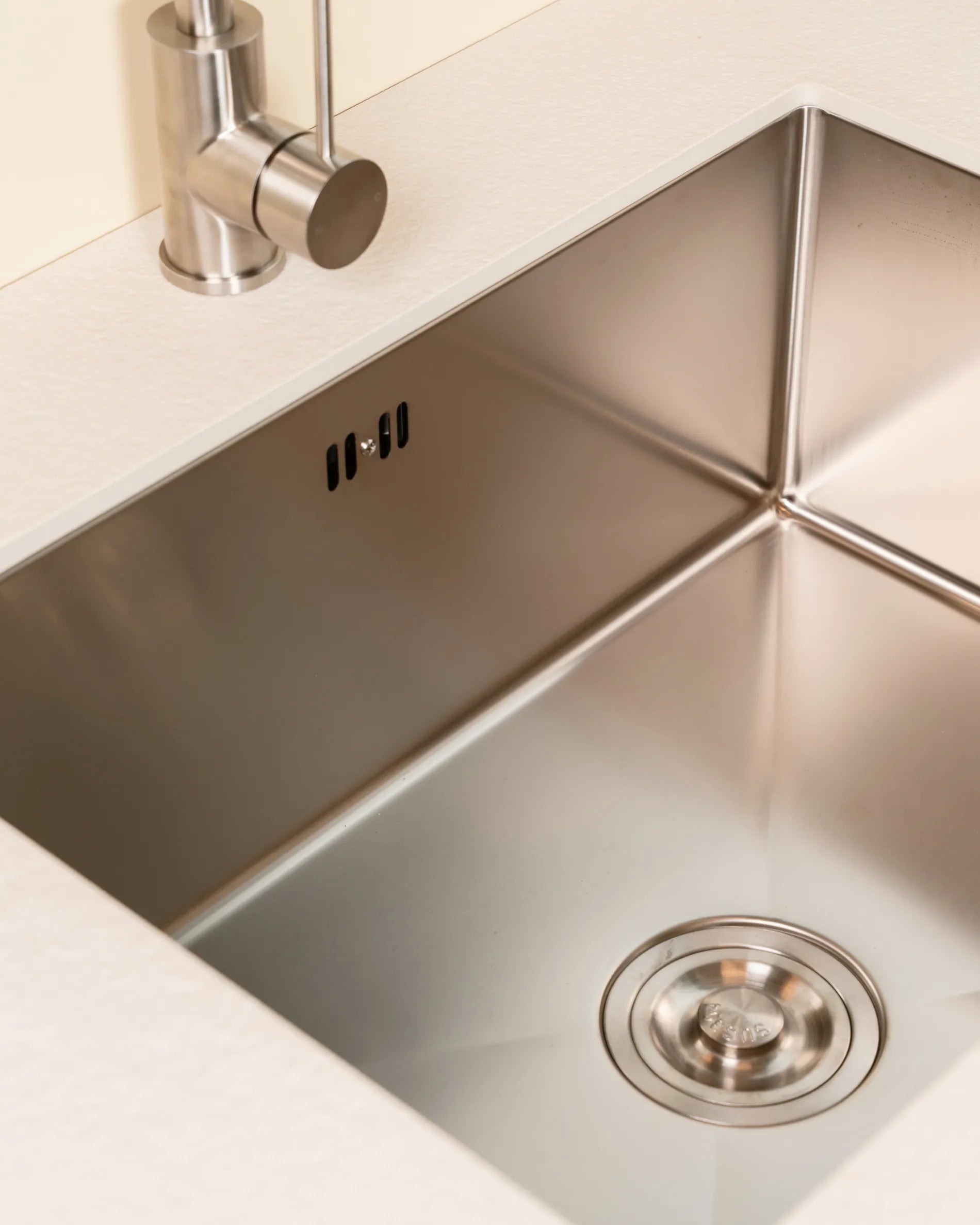 Vasque inox du module Évier PILOTIS encastrée dans plateau beige crème, gros plan