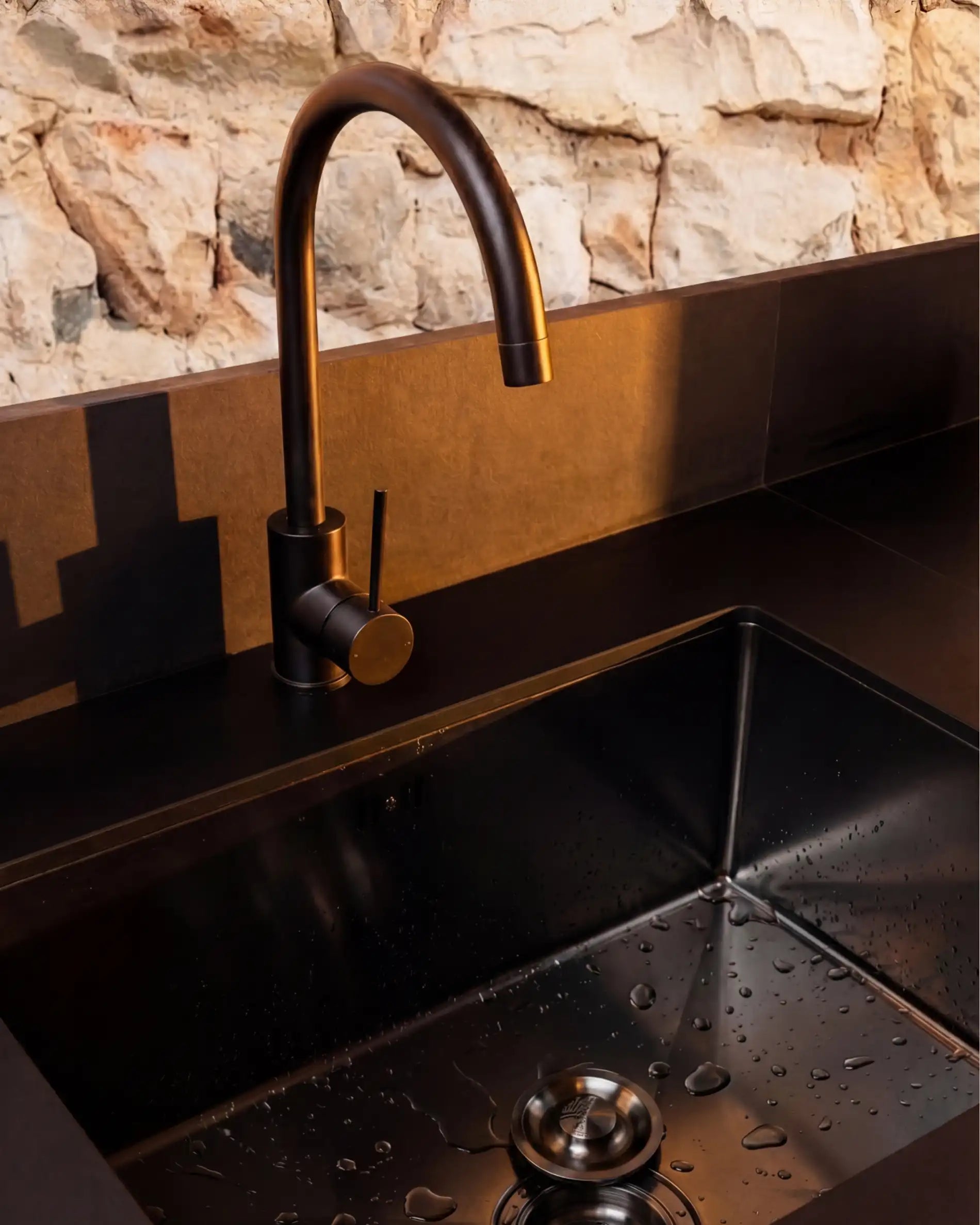 Détail évier inox avec robinet noir sur cuisine extérieure Kokko