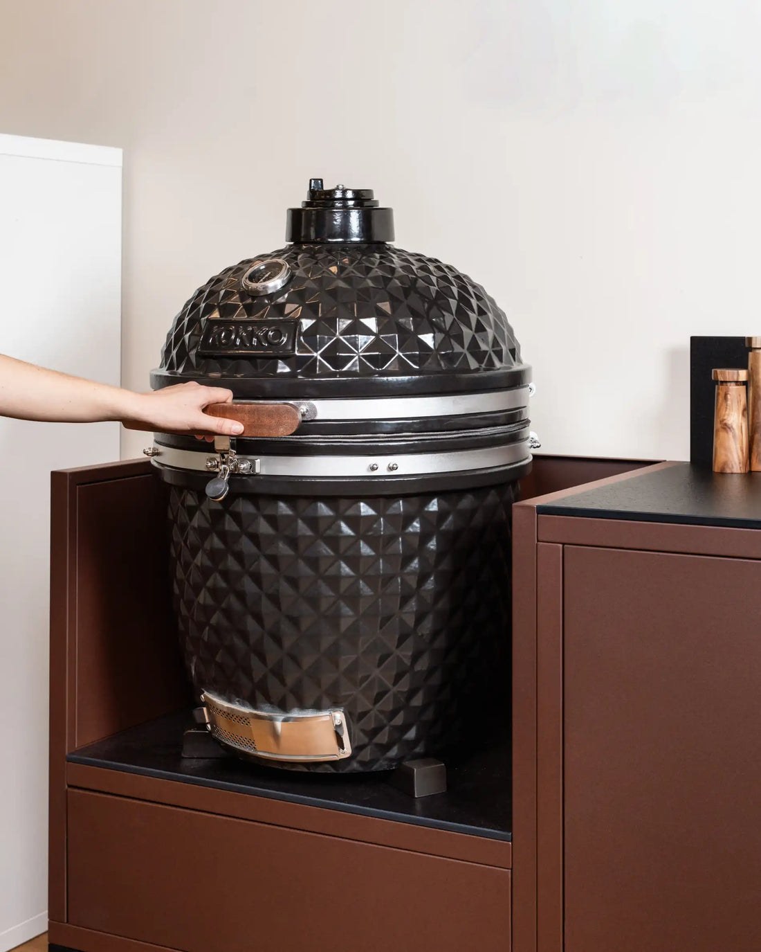 Kamado Kokko noir exposé dans le showroom avec cuisine d'extérieure Pilotis.