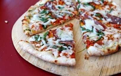 Pizza con tocino, queso mozzarella y rúcula
